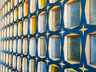 Glass block wall with wood of blue-yellow colors. Side view. Wall with pattern, texture