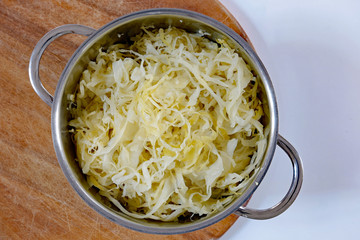 Sauerkraut im Topf auf Holzbrett