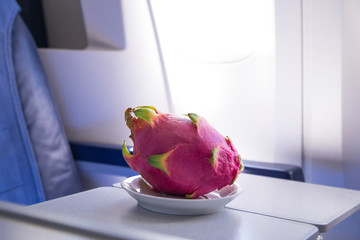 fresh pink dragonfruit on the table in the plane for dinner during flight to tropic country