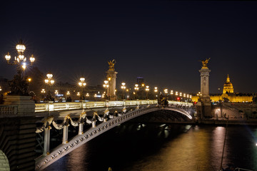 Obraz premium Paris, France - November 17, 2018: Alexandre 3 bridge and Invalide dome at night in Paris
