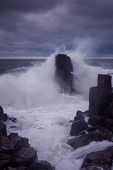 Dramatic nature background - big waves and dark rock in stormy sea, stormy weather. Dramatic scene. Contrasting colors.Beautiful natural landscape. Seascape at Palikari, Sozopol, Bulgaria.