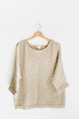 Female pullover on hanger at white wall. Woman fashion clothes concept.