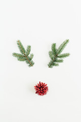 Christmas, New Year minimal concept. Christmas deer symbol made of fir branches and red pompon isolated on white background. Flat lay, top view.