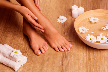 Fototapeta na wymiar The picture of ideal done manicure and pedicure. Female hands and legs in the spa spot.