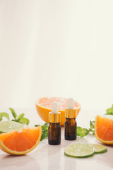 organic cosmetics with herbal extracts of lemon, orange, mint on bright background