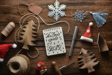 Christmas composition. Christmas gift, santa hat, pine tree, on wooden background. Flat lay, top view, copy space