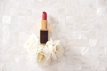 Lipstick with beautiful flowers on white background