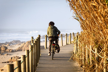 Boy Rides Bike on Boardwalk