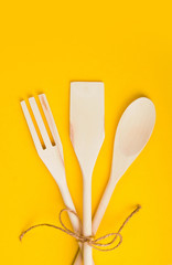 Natural wooden cooking kit on yellow background. Organic food concept.