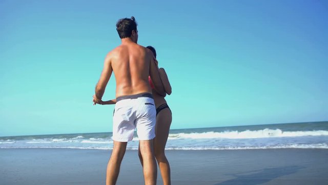 Young happy multi ethnic male and female dancing and having fun on their beach vacation