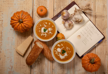 Pumpkin soup recipe with pumpkin soup and ingredients on a wooden background 