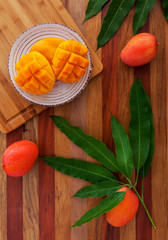 Mango fruit and mango drink on the wooden cutting board. Tropical fruit.
