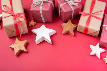 Christmas composition. Christmas red decorations, stars and gift boxes on red background. Flat lay, top view, space for the text