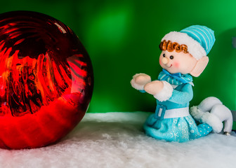 Elf gazing at holiday ornament