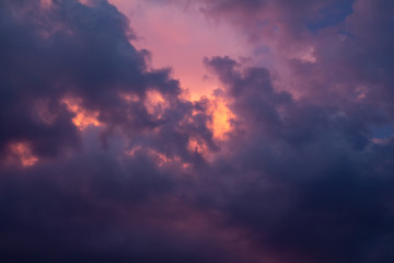 Storm clouds at sunset. Dramatic sky. Dark blue clouds against the setting sun. Photo of the fiery sky at sunset. Fire clouds against the sky. Suitable for any design.