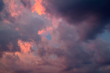 Storm clouds at sunset. Dramatic sky. Dark blue clouds against the setting sun. Photo of the fiery sky at sunset. Fire clouds against the sky. Suitable for any design.