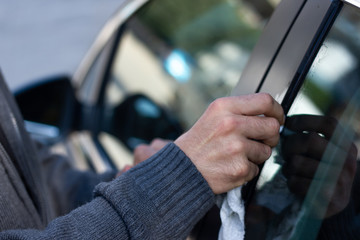 Man cleaning bird droppings in his car