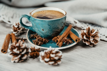 Fototapeta na wymiar turquoise cup of hot coffee with cinnamon sticks on grey background