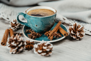 turquoise cup of hot coffee with cinnamon sticks on grey background