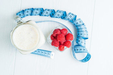 Raspberry smoothies and a centimeter for measuring the waist, top view