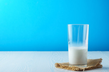 A glass of milk on a napkin half full