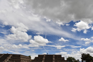 Fototapeta premium A happy young woman on top of the sun pyramid in Teotihuacán.
