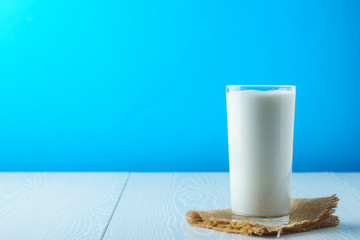 Full glass of milk on a blue background
