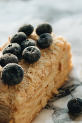 Piece of delicious cake with blueberries on marble table, sweet dessert
