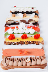Set of delicious eclairs with glaze, colorful dessert