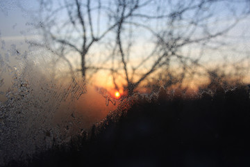 Frosty patterns of Santa Claus on the windows. Christmas Eve, New Year's Eve. Fantastic view from the window, winter landscape, sun, white snow, magic snowflakes. Background for New Year greeting card