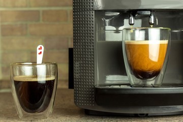 Home professional coffee machine with espresso cup. Coffee preparation. Espresso coffee maker machine and glass with hot coffee