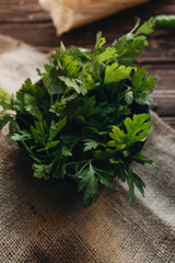 Bunch of fresh green parsley twigs on wooden background