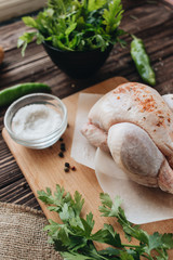 Raw chicken and fresh herbs on wooden table ready for cooking