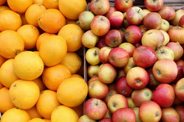 Naklejka na ściany i meble Lots of fresh organic red apples and juicy oranges on the market pattern background