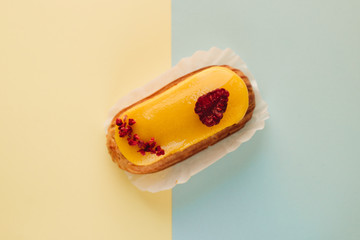 Delicious eclair with yellow glaze, sweet dessert