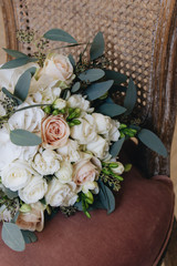 Beautiful spring bouquet of tender pink roses on chair, elegant floral decoration