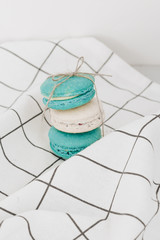 Composition of delicious macaroons on table cloth, sweet dessert
