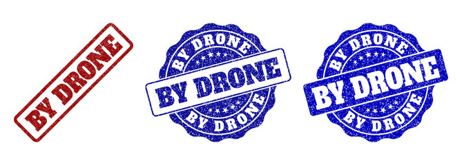 Obraz premium BY DRONE grunge stamp seals in red and blue colors. Vector BY DRONE overlays with grunge surface. Graphic elements are rounded rectangles, rosettes, circles and text captions.