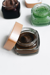 Assortment of different jams in small jars on white background, top view