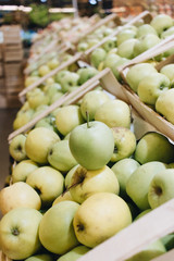 Pile of fresh ripe green apples in boxes at market