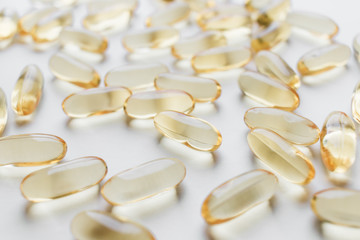 Pile of scattered capsules with medication on white background