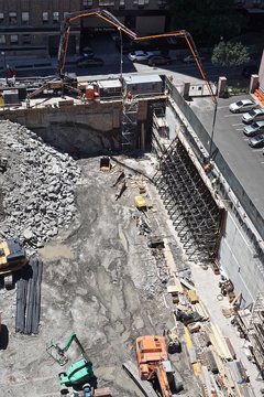 New York City, New York, USA: Workers use a cement mixer with a long arm to construct a retaining wall as construction begins on a high-rise apartment building in Manhattan.