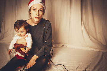 sad mother with baby is frustrated from christmas stress
