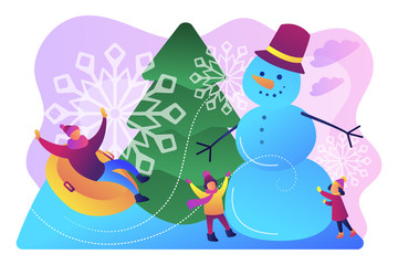 Happy people having fun outdoor in winter sledding and making snowman