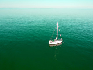 Sailing ship yacht with sails at opened sea. Aerial  drone view of sailboat at summer.