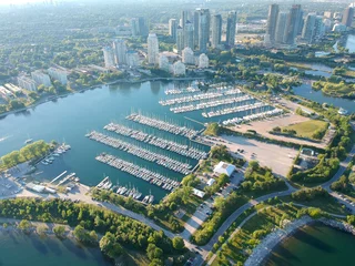 Zelfklevend Fotobehang Toronto Aerial bird eye shot over Humber Bay Shores Park, Toronto, Canada with coastal condo homes, blue skies, beaches and harbour entrance in view with glass condominiums. Perfect summer day sunset.