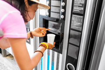 woman buying coffee from automatic vending machine
