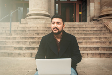 Asian businessman outdoor using internet. Freelance concept.