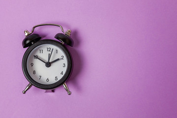 Ringing twin bell vintage classic alarm clock Isolated on purple violet pastel colourful...
