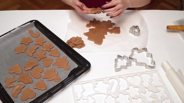 Close up of girls hands making homemade gingerbread cookies. Christmas baking. Dough and form for ginger cookies. Girl rolls dough and cut figures with cookie cutter